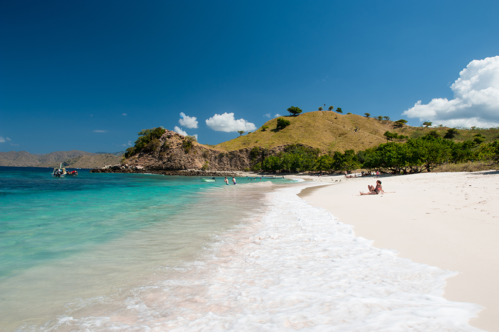 Pantai Merah albo Pink Beach po angielsku zawdzięcza swoją nazwę kolorowi piasku,  czerwonawego z powodu czerwonawych koralowców.